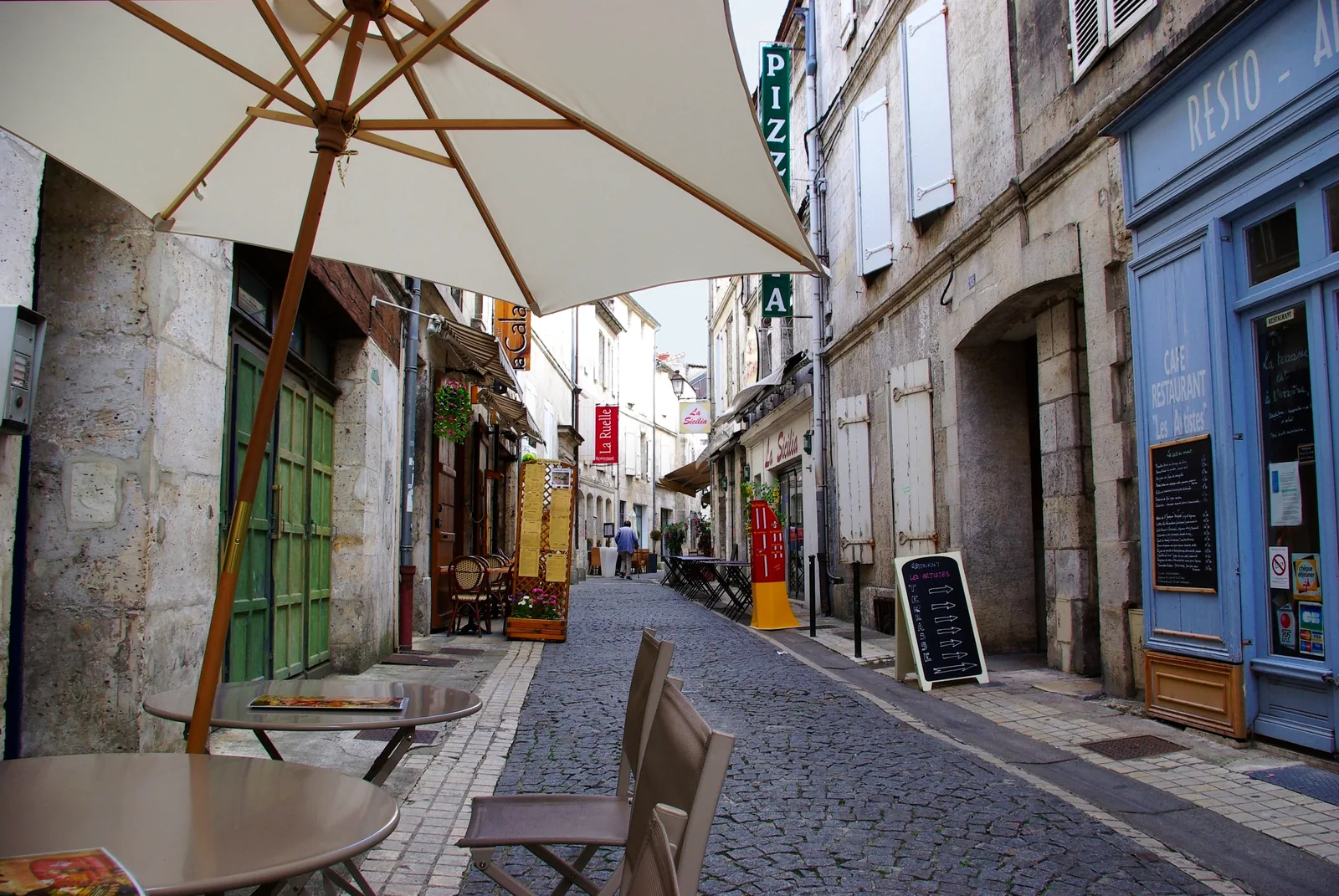 Rue commerçante du vieil Angoulême avec terrasse de café, ambiance commerces de proximité